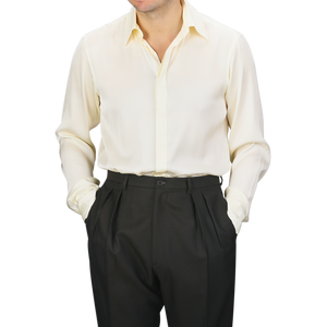 A person wearing a Cream Silk Fitted Body Shirt by Stenströms, paired with black pants, stands with hands in pockets.