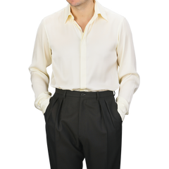 A person wearing a Cream Silk Fitted Body Shirt by Stenströms, paired with black pants, stands with hands in pockets.