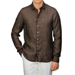 Someone is wearing a Stenströms Dark Brown Linen Cutaway Fitted Body Shirt with white buttons, paired with crisp white pants.