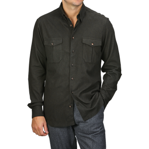 A person wearing a Dark Green Cotton Flannel Fitted Body Shirt by Stenströms from a capsule collection with two chest pockets and gray trousers, standing with one hand in a pocket.