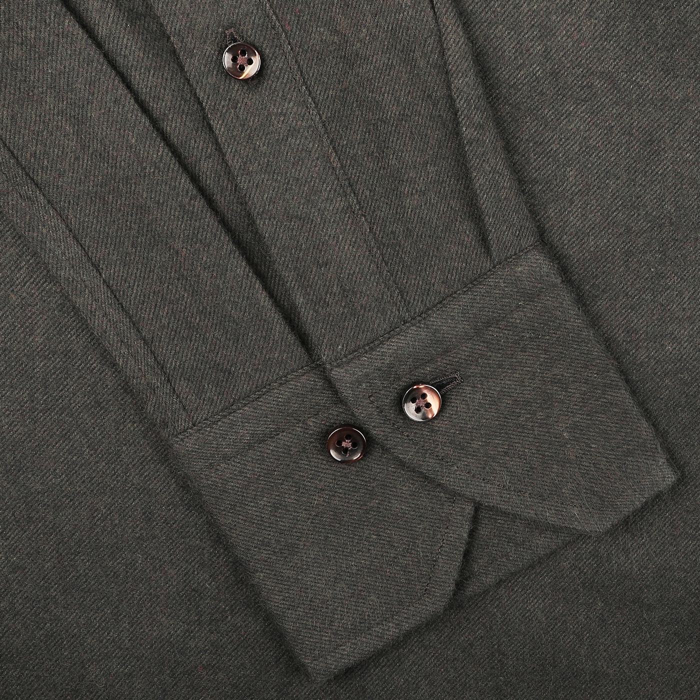 Close-up of a folded dark green melange dress shirt in cotton flannel, showcasing sleek buttons and a pointed cuff, by Stenströms.