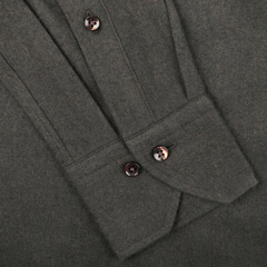 Close-up of a folded dark green melange dress shirt in cotton flannel, showcasing sleek buttons and a pointed cuff, by Stenströms.