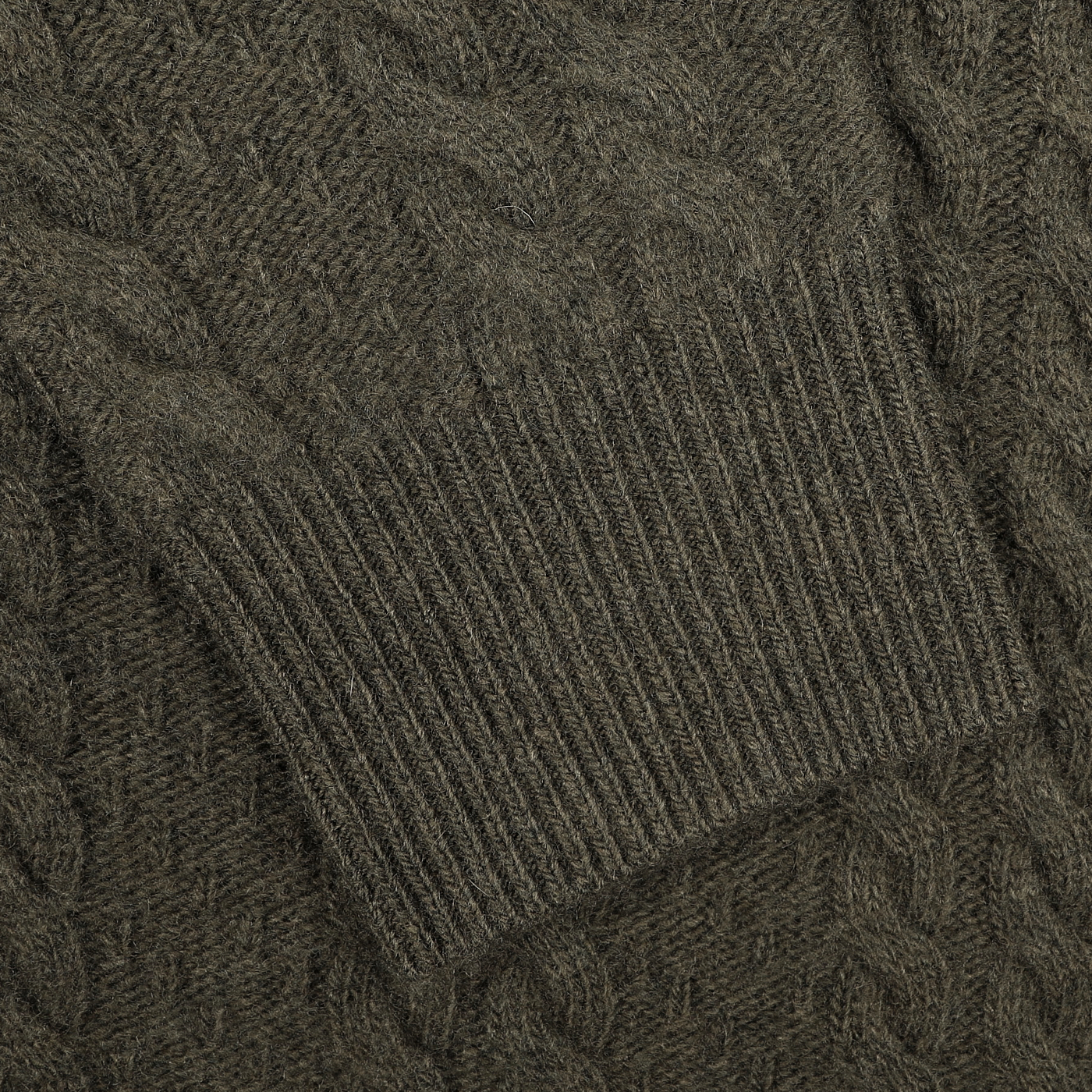 Close-up of the sleeve from the Dark Green Merino Cable Knit LS Polo by Stenströms, featuring a ribbed cuff as part of their exclusive capsule collection.