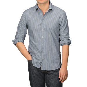 A person wearing a Stenströms Dark Indigo Striped Washed Cotton Fitted Body Shirt and dark jeans stands with one hand in a pocket.