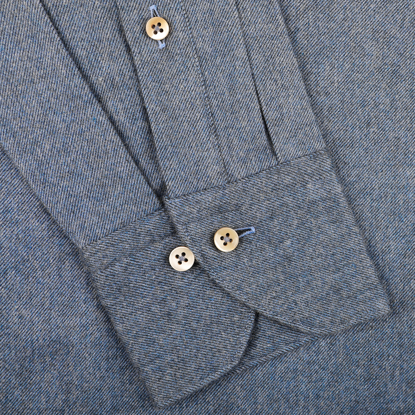 Close-up of the cuff from Stenströms' Denim Blue Cotton Flannel Cut-Away Slimline Shirt, featuring a herringbone pattern with two beige buttons on the sleeve, crafted from brushed cotton twill for a luxurious feel.