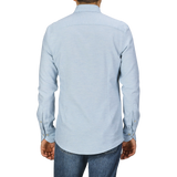 A person, seen from behind, wearing a Light Blue Cotton Flannel Slimline BD Shirt by Stenströms and blue jeans against a plain background.