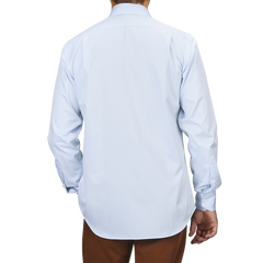 Someone wearing a Light Blue Cotton Twill Fitted Body Shirt by Stenströms, paired with brown pants, is viewed from the back.