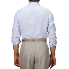 A person is seen from the back in a Stenströms Light Blue Micro-Checked Linen Slimline Shirt, sleeves rolled up and paired with beige trousers, epitomizing effortless summer style.