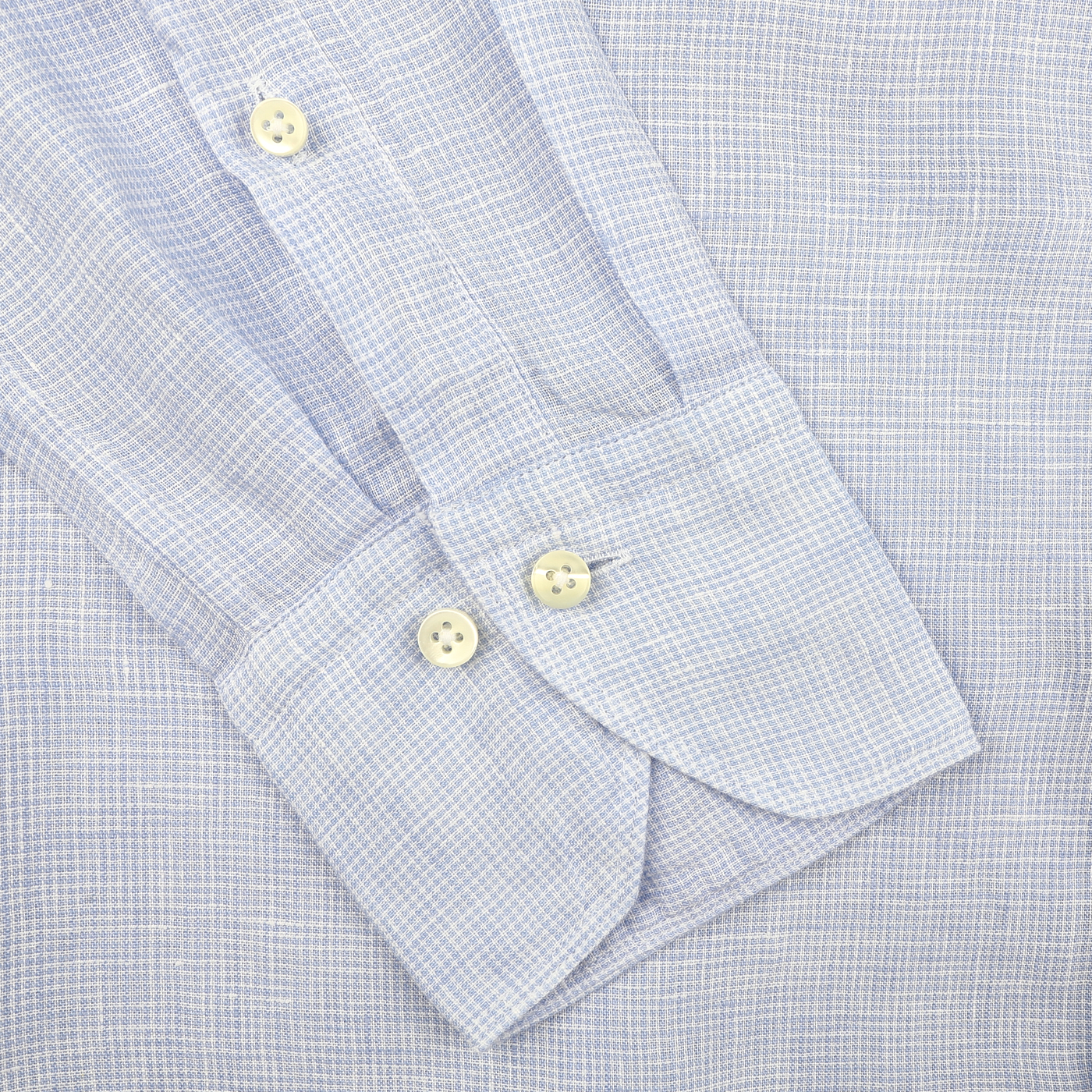 Close-up of Stenströms' Light Blue Micro-Checked Linen Slimline Shirt sleeve, showcasing two cream buttons and a buttoned cuff on a matching fabric background. A true summer essential for effortless style.