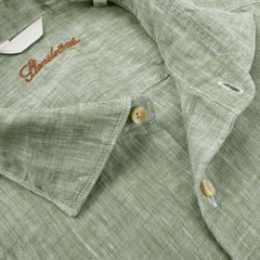 Close-up of the Stenströms Light Green Linen Cutaway Fitted Body Shirt featuring cream buttons and an embroidered brand name on the collar, making it a summer essential.