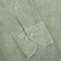 A close-up of a Light Green Linen Cutaway Fitted Body Shirt by Stenströms showcases a textured sleeve with two wooden cuff buttons, white stitching near the buttons, and effortless summer style.