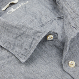 Close-up view of a light grey Stenströms linen slimline shirt fabric with detailed stitching and buttons.
