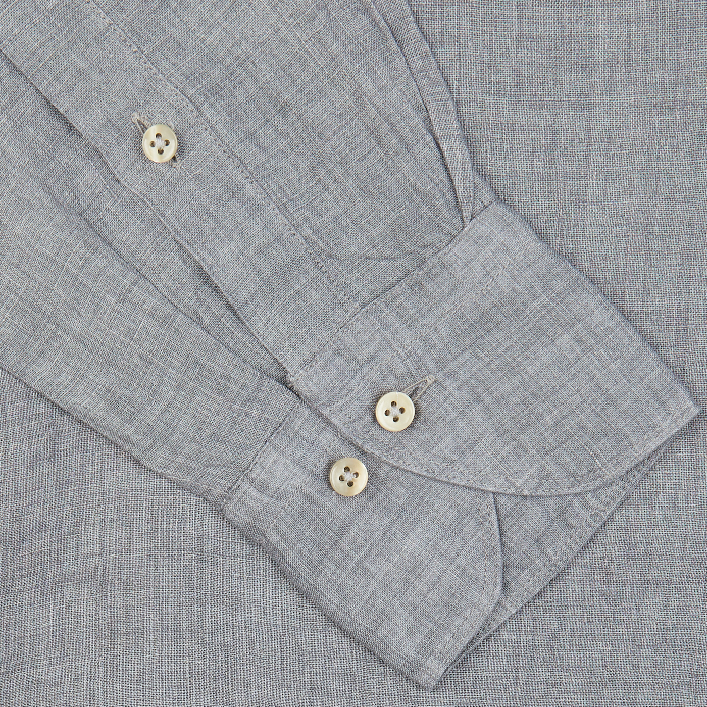 Close-up of a grey suit jacket sleeve with buttoned cuffs and Stenströms' Light Grey Linen Fitted Body Shirt.