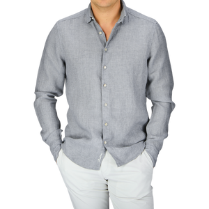 Man wearing a Stenströms Light Grey Linen Fitted Body Shirt with a cutaway collar and white pants.