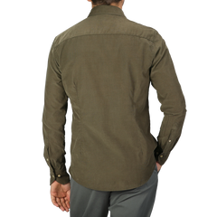 A person in a Moss Green Cotton Corduroy Slimline Shirt by Stenströms is standing with their back facing the camera, wearing gray pants.