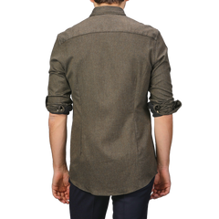 The image shows the back of a person wearing a slimline cut, long-sleeved shirt with rolled-up sleeves and dark pants. The shirt, the Moss Green Cotton Flannel Cut-Away Slimline Shirt by Stenströms, crafted from brushed cotton twill, adds a touch of sophistication to the casual look.