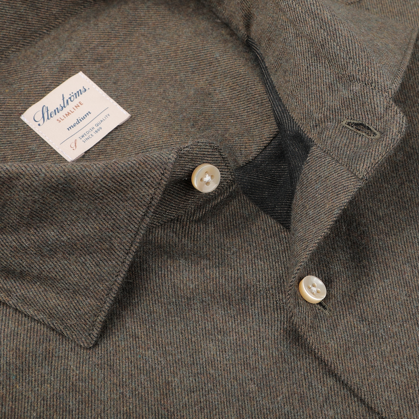 The close-up features a Moss Green Cotton Flannel Cut-Away Slimline Shirt by Stenströms, highlighting its open collar, white buttons, and visible label.