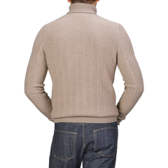 Rear view of a person wearing the Taupe Beige Structured Merino Rollneck by Stenströms, potentially part of a versatile capsule collection, paired with blue jeans.