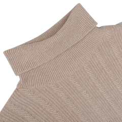 Close-up of the Taupe Beige Structured Merino Rollneck by Stenströms on a light gray background. The textured merino wool fabric is visible, highlighting a classic cable knit pattern ideal for any capsule collection.