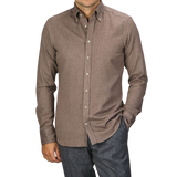 A person wearing a Taupe Brown Cotton Flannel Slimline BD Shirt by Stenströms and dark gray pants stands with one hand in their pocket.