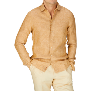 A man in a Stenströms Tobacco Brown Linen Fitted Body Shirt and tan pants, the perfect summer essential outfit.