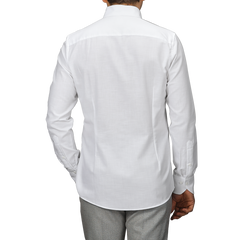 Rear view of a person in a Stenströms White Soft Cotton BD Slimline Shirt paired with gray pants against a plain background.