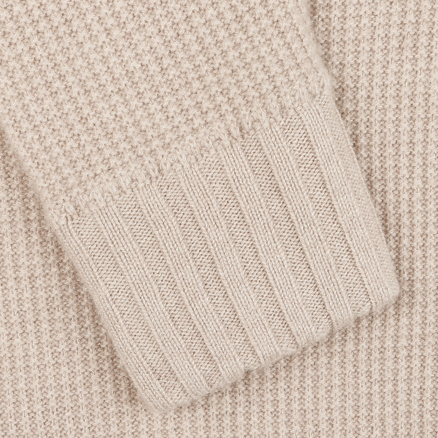 Close-up of the luxurious sleeve of a light beige cashmere fur collar cardigan, bearing the refined craftsmanship of Stile Latino.