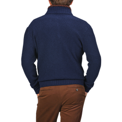 A person in a Royal Blue Cashmere Fur Collar Cardigan by Stile Latino and brown trousers, viewed from behind, stands against a neutral background.