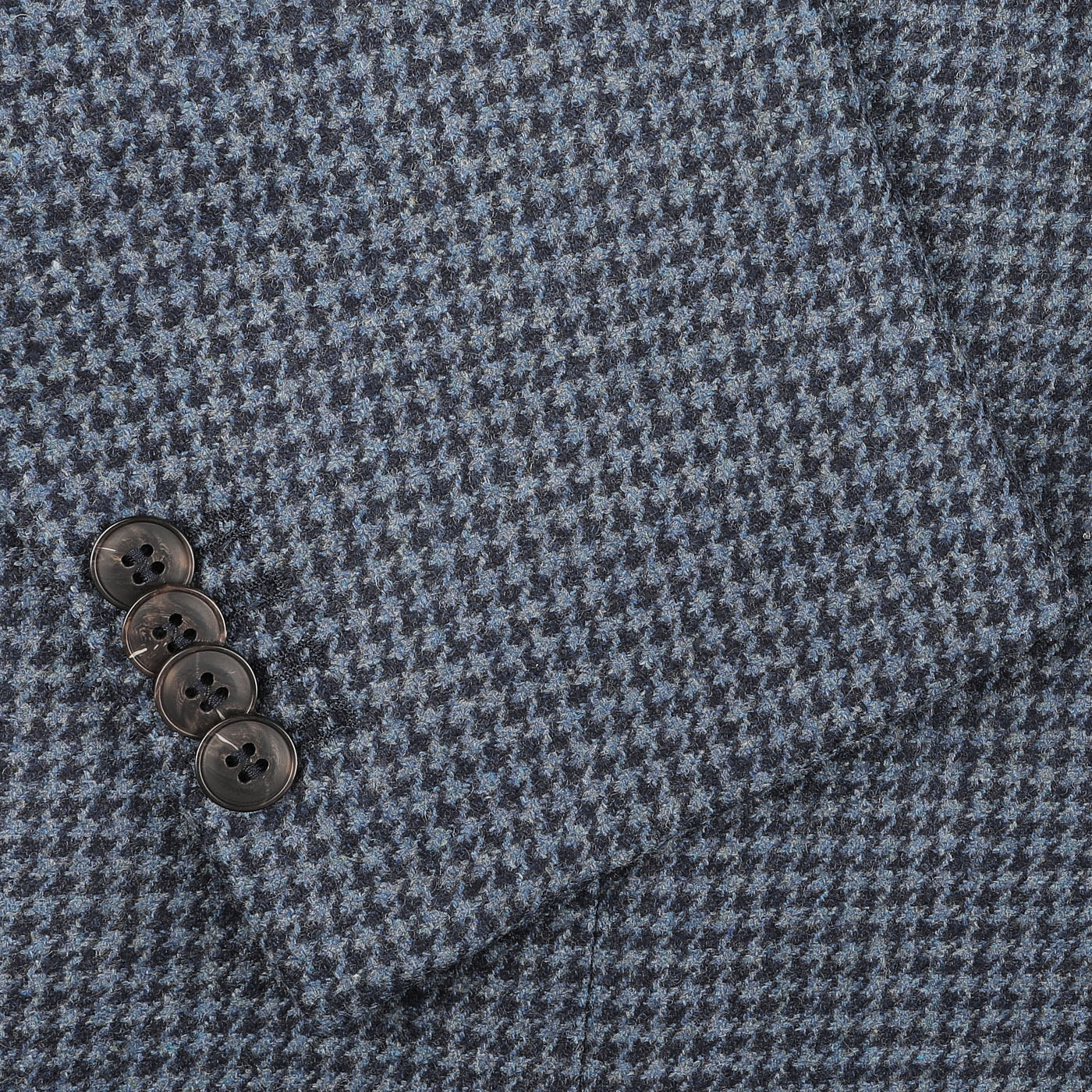 Close-up of a Blue Houndstooth Wool Flannel Blazer by Studio 73, showcasing a regular fit with sleeves adorned with four black buttons.