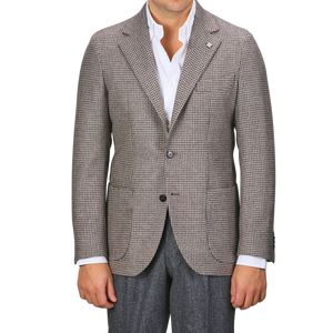 A person wearing a regular fit, brown houndstooth lambswool blazer from Studio 73 over a white shirt and dark trousers.