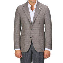 A person wearing a regular fit, brown houndstooth lambswool blazer from Studio 73 over a white shirt and dark trousers.