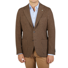 A man wearing a brown Houndstooth Wool Cashmere Blazer by Studio 73 and tan pants.