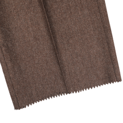 Close-up of the Brown Melange Wool Flannel Pleated Trousers by Studio 73, showcasing the soft texture reminiscent of pure wool flannel tailored trousers. The bottom edge features a distinctive zigzag cut.