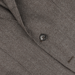 Close-up of a Studio 73 Brown Micro-Houndstooth Wool Flannel Suit blazer, showing one round black button and a small part of a darker buttonhole stitch on the right side.