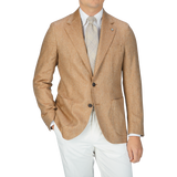 A man wearing a Studio 73 Camel Brown Herringbone Pure Silk Blazer and silk white pants.