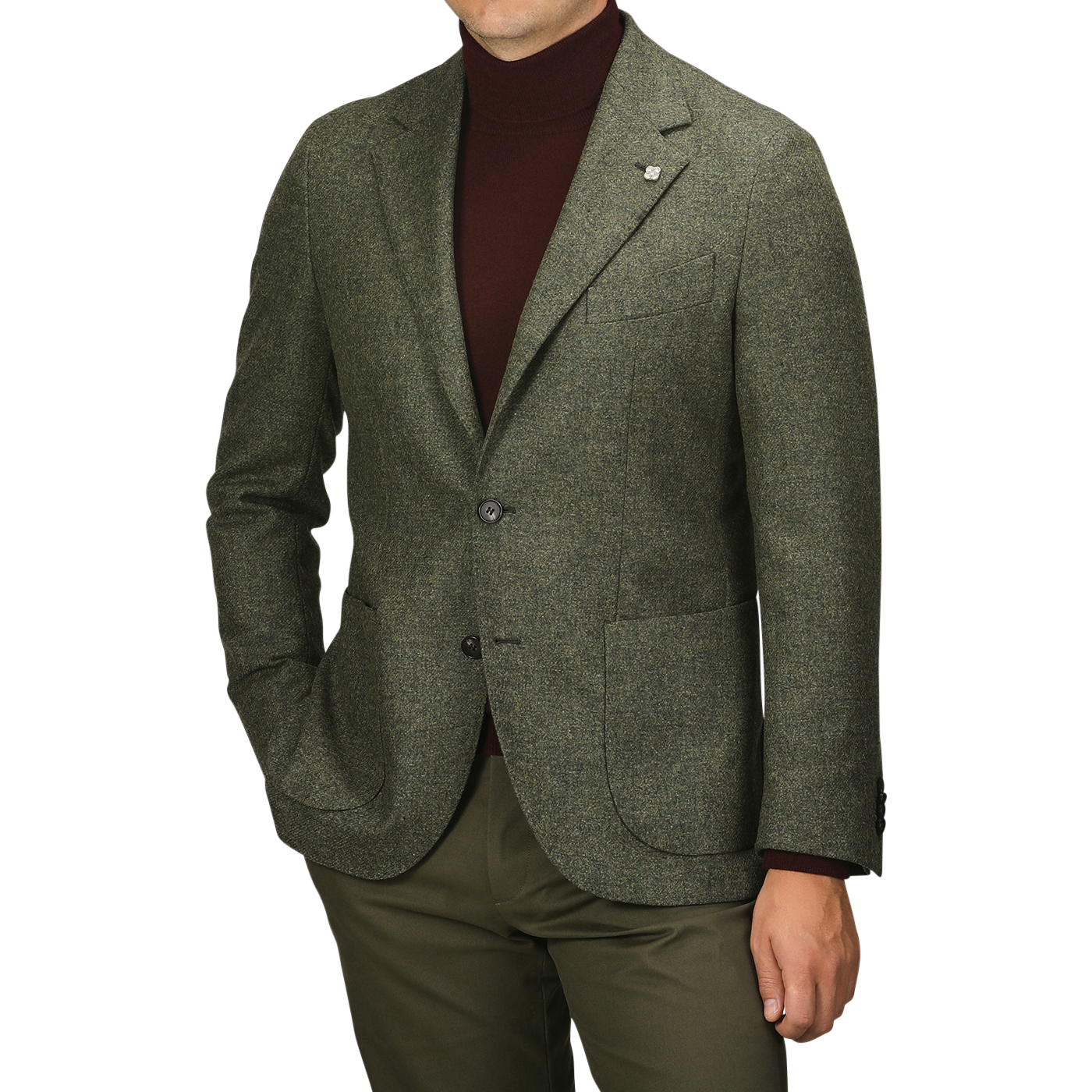 A person wearing the Studio 73 Green Melange Wool Tweed Blazer over a brown turtleneck and olive pants stands against a plain background. The individual is shown from the shoulders down.