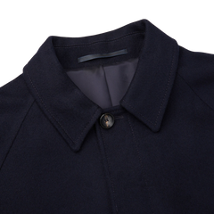 A close up of a Studio 73 navy wool cashmere raglan coat on a white background.