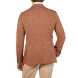 The back view of a man wearing a Studio 73 Orange Herringbone Wool Tweed Blazer.