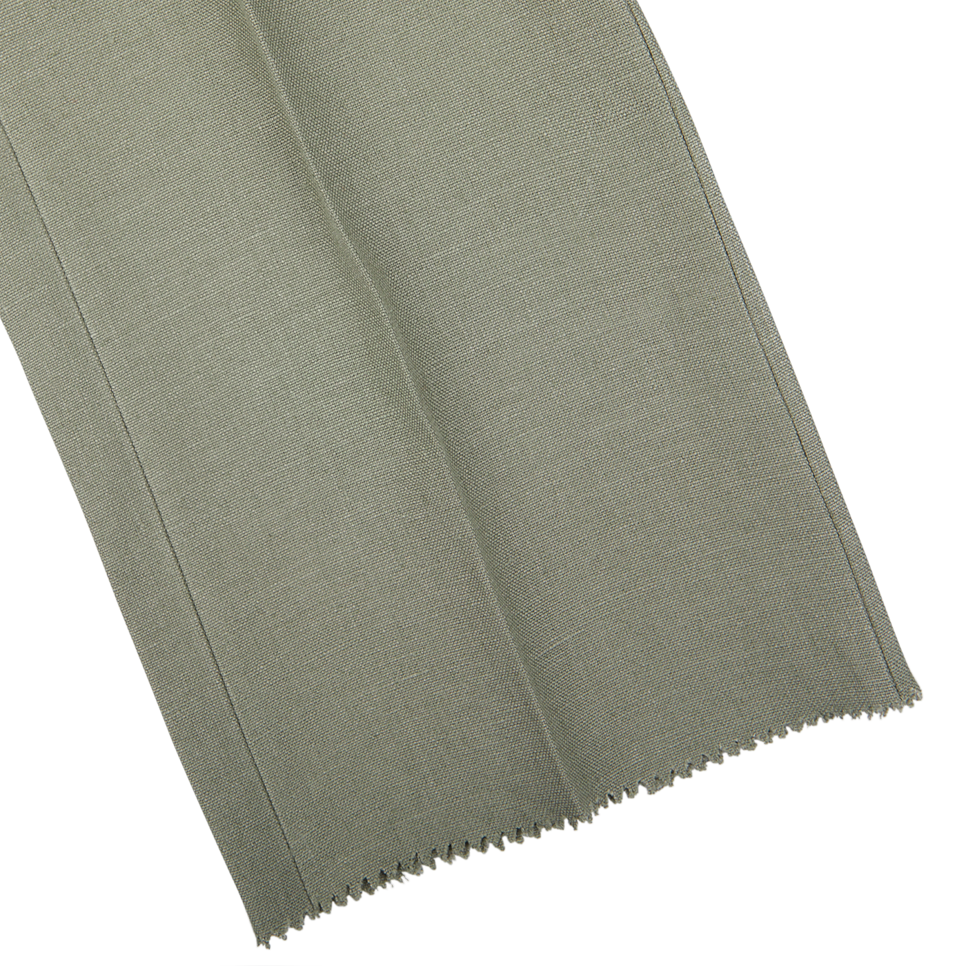 A piece of light grey, textured fabric on a white surface with a zigzag cut along the bottom edge, reminiscent of the exquisite craftsmanship found in Studio 73's Sage Green Canapa Hemp DB Suit.