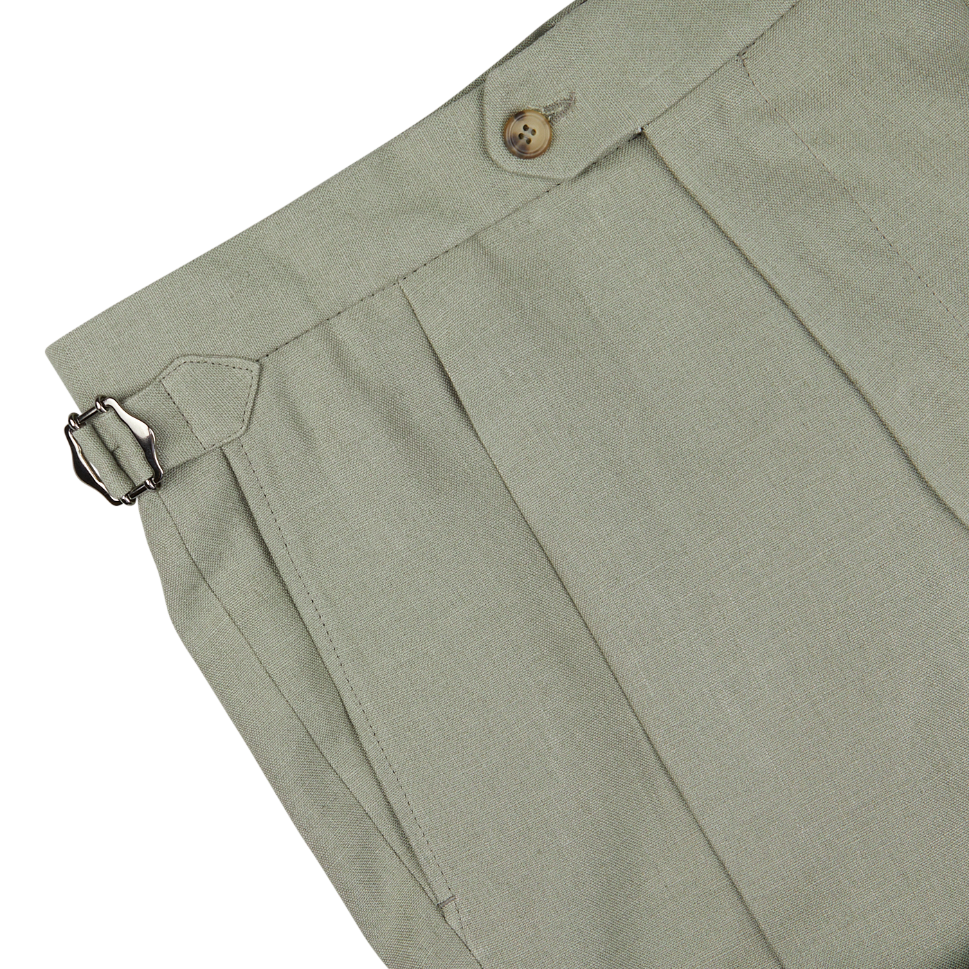Close-up of light gray pants from a Sage Green Canapa Hemp DB Suit by Studio 73, featuring a side adjuster and a brown button at the waist. The fabric appears to be light and finely textured, with pleats near the waistband.