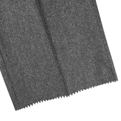 Close-up image of Studio 73's Dark Grey Wool Flannel Pleated Trousers, showcasing a seam running vertically through the pure wool material and zigzagged edges.