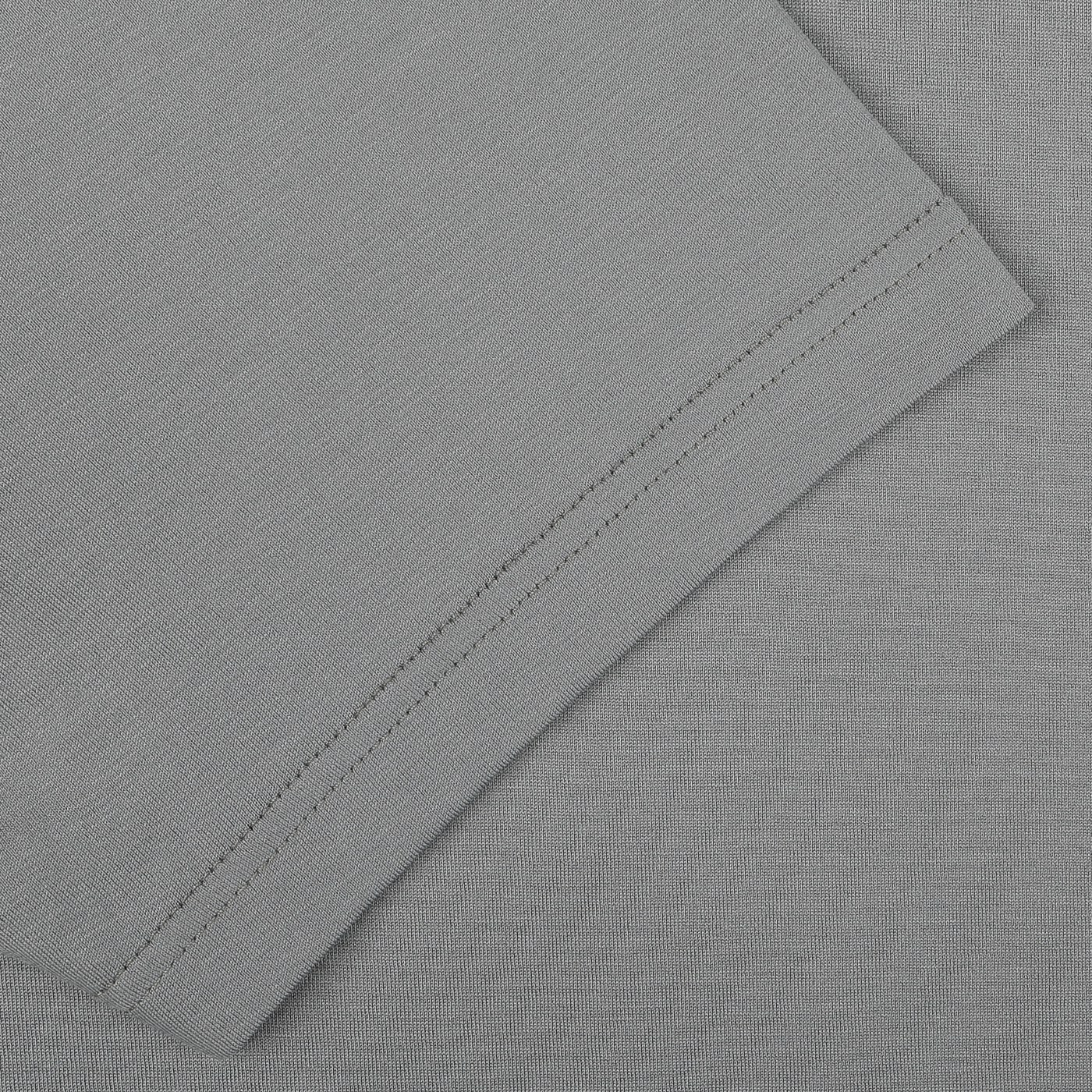 Close-up of a neatly sewn hem on a smoke green cotton fabric, showcasing the fine craftsmanship of this Classic Fit Crew Neck T-Shirt from Sunspel.