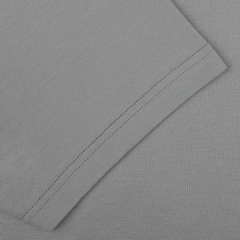 Close-up of a neatly sewn hem on a smoke green cotton fabric, showcasing the fine craftsmanship of this Classic Fit Crew Neck T-Shirt from Sunspel.