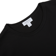 Close-up of a Black Classic Cotton T-Shirt by Sunspel, highlighting the label that verifies it's a classic fit, crafted from 100% cotton and size medium—an ideal wardrobe staple.