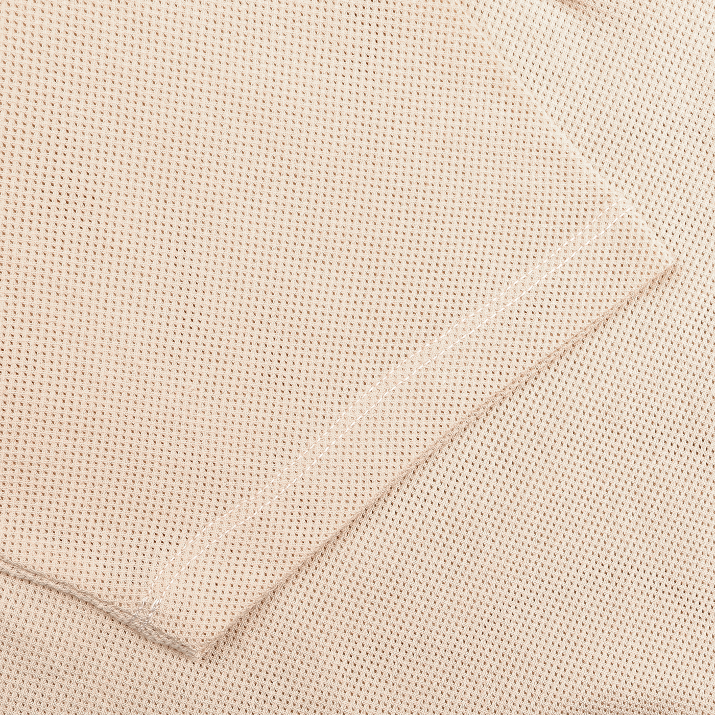 A close-up of the Ecru Beige Cotton Riviera Polo Shirt by Sunspel reveals its waffle fabric texture and neat edge stitching.