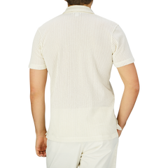 The back view of a man wearing a Sunspel Ecru White Linear Cotton Mesh Polo Shirt.