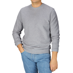 A man wearing a Sunspel Grey Melange Cotton Loopback Sweatshirt and jeans.