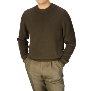 A man wearing a Khaki Green Cotton Waffle Stitch Crew Neck sweater and pants by Sunspel.