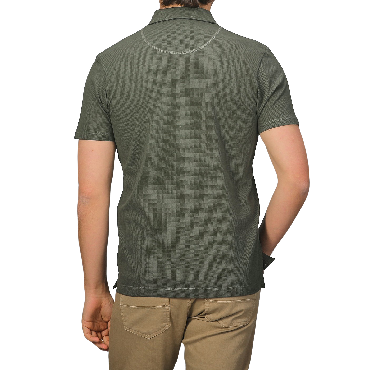 From the back, a person in a Sunspel Pine Green Cotton Riviera Polo Shirt and khaki pants exemplifies a contemporary aesthetic.