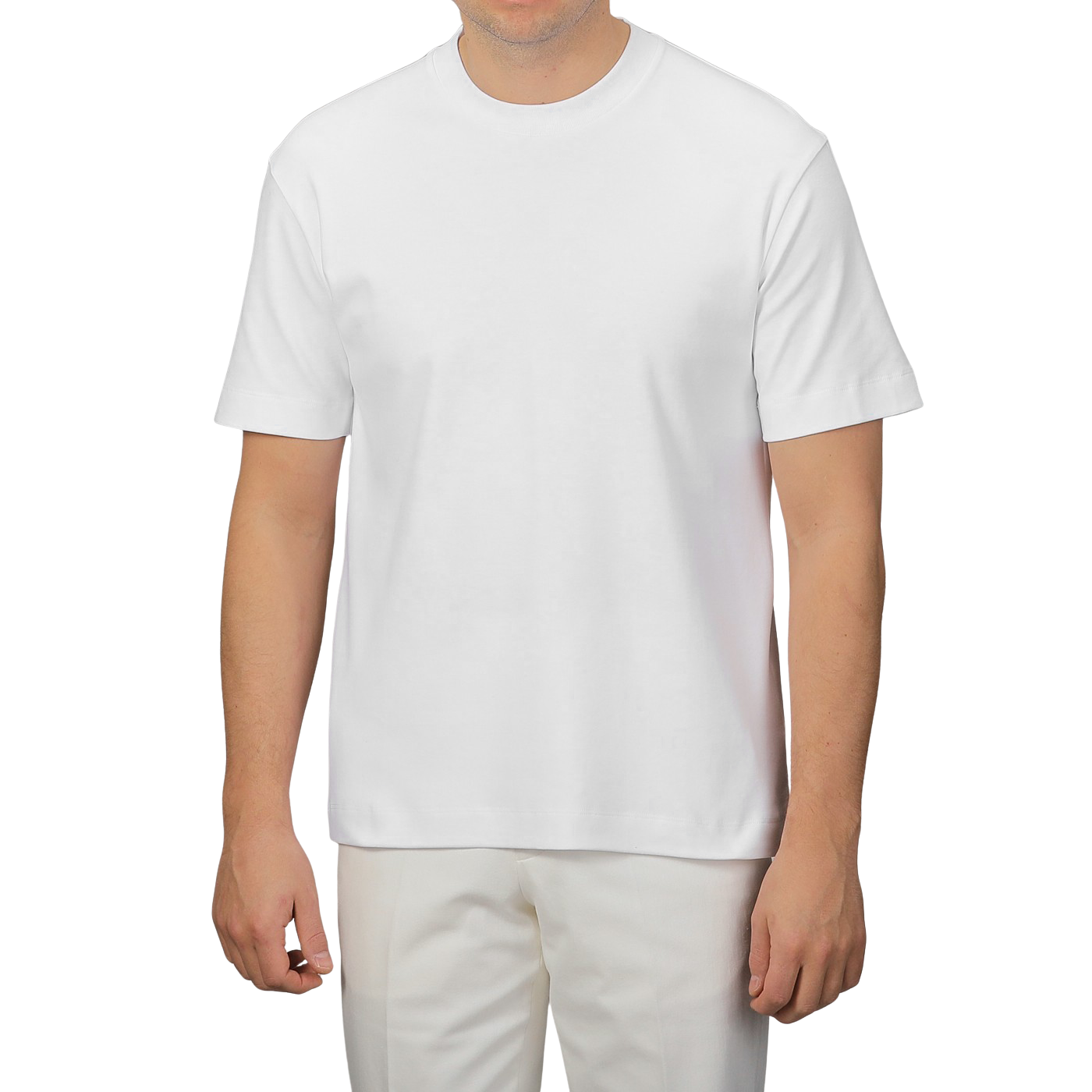 A person poses effortlessly against a neutral background, wearing a Sunspel White Supima Cotton Relaxed Fit T-shirt and matching pants, showcasing style and comfort.